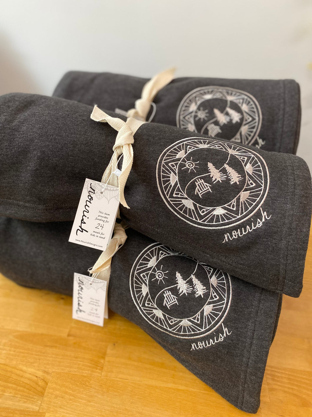 Image of Rolled up gray Jersey Blankets with ADK designed. 