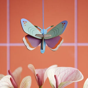 product photo  butterfly ornament hanging above flowers