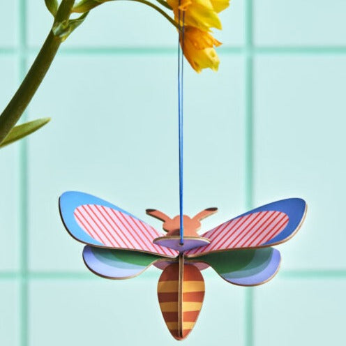 product photo bee ornament hanging from flower