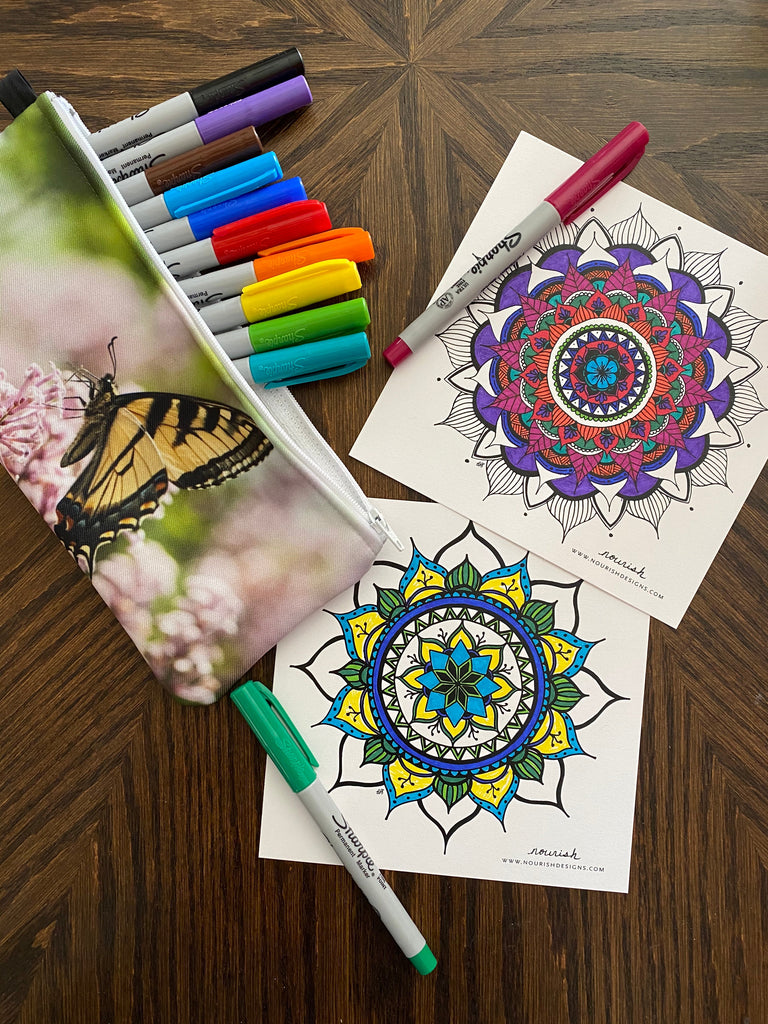 two partially colored coloring cards with markers and a pencil pouch.