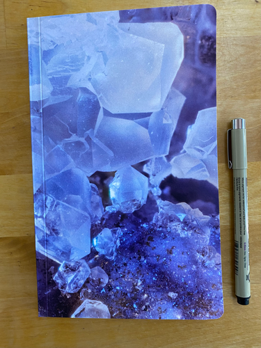 product photo:  notebook of a macro photograph of crystals from the middle of a geode with pen