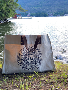 Image of the Large Tote Bag with the ADK Mandala sitting on the lakeshore 