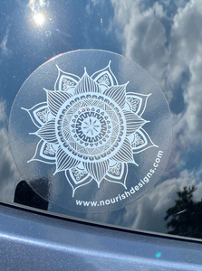View of the window sticker on the window of a car with sun and clouds in the reflection