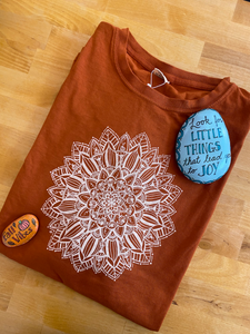 Lay flat image of folded pumpkin mandala design shirt with 2 painted rocks with sayings "Look for little things that lead you to joy."  " Fall Vibes 